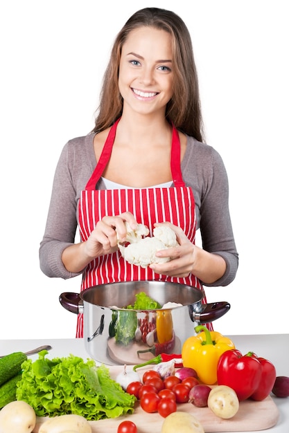 Jeune belle femme avec la cuisson des légumes frais