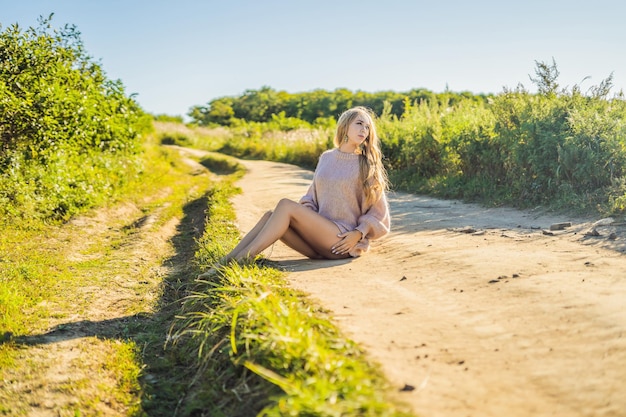 Jeune belle femme dans un paysage d'automne avec des épis de blé de fleurs sèches