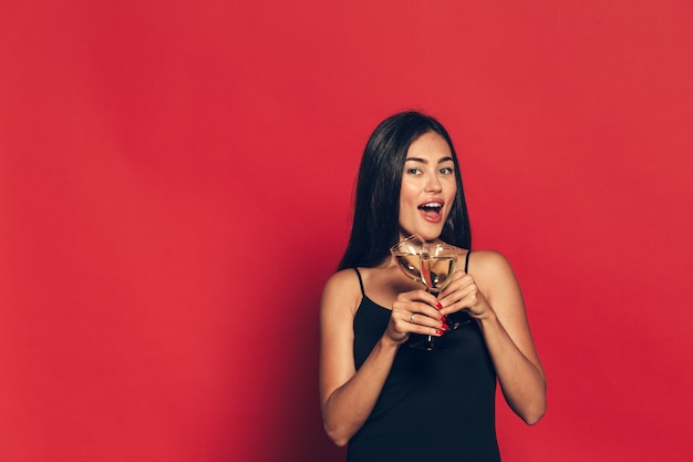 Une jeune et belle femme dansant avec une coupe de champagne