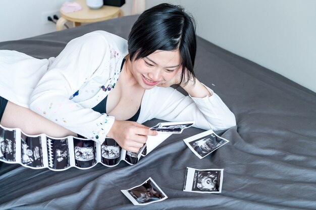 Jeune belle femme enceinte asiatique avec film à ultrasons