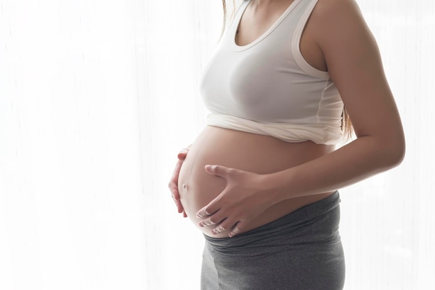 Jeune belle femme enceinte à la maison concept de soins de maternité et de grossesse