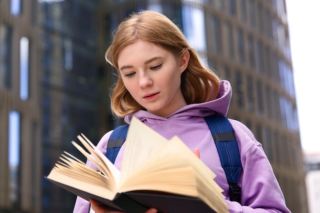 Jeune belle femme étudiante universitaire ou universitaire fille ou élève est en train de lire un livre