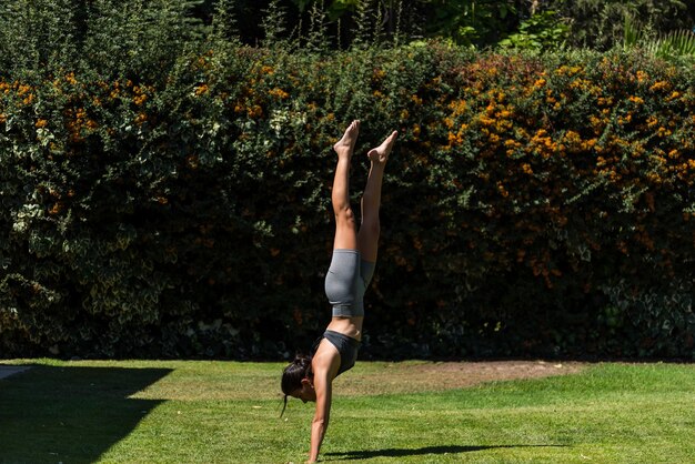 Jeune et belle femme faisant de la gymnastique dans le jardin de sa maison