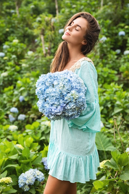 Jeune et belle femme fleuriste collecte des fleurs d'hortensia dans le domaine