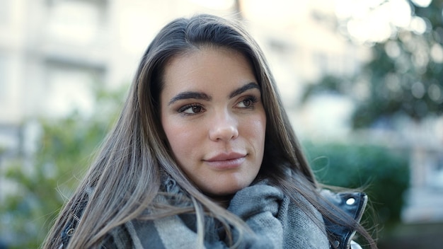 Jeune belle femme hispanique debout avec une expression sérieuse dans la rue