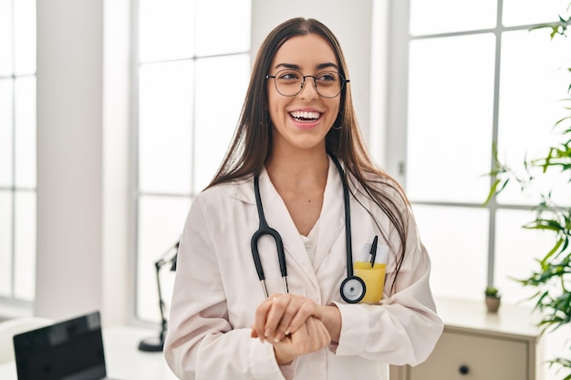 Jeune belle femme hispanique médecin souriant confiant debout à la clinique