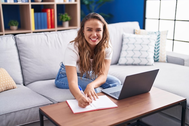 Jeune belle femme hispanique utilisant un ordinateur portable écrivant sur un ordinateur portable à la maison