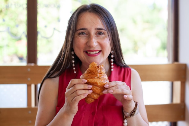 Jeune belle femme mangeant un croissant