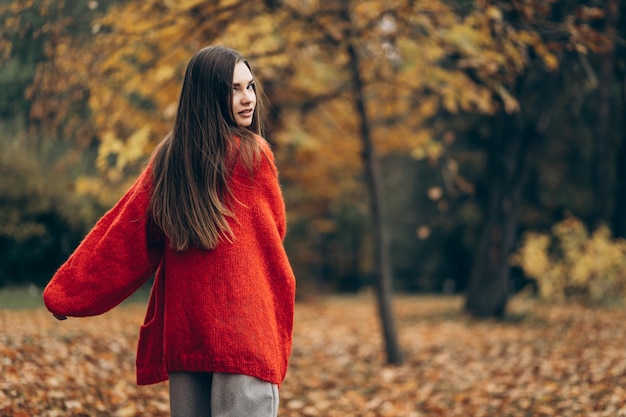 Jeune belle femme marchant dans le parc d'automne