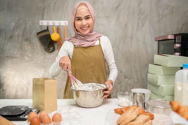 Jeune belle femme musulmane cuit dans sa boulangerie de cuisine et café-restaurant