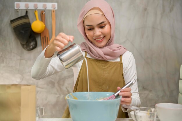 Jeune belle femme musulmane cuit dans sa boulangerie de cuisine et café-restaurant