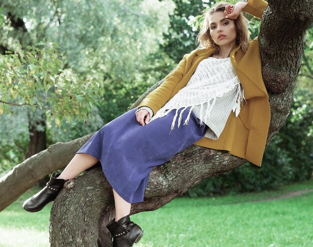 Jeune belle femme posant sur un arbre Portrait de mode glamour Parc d'automne