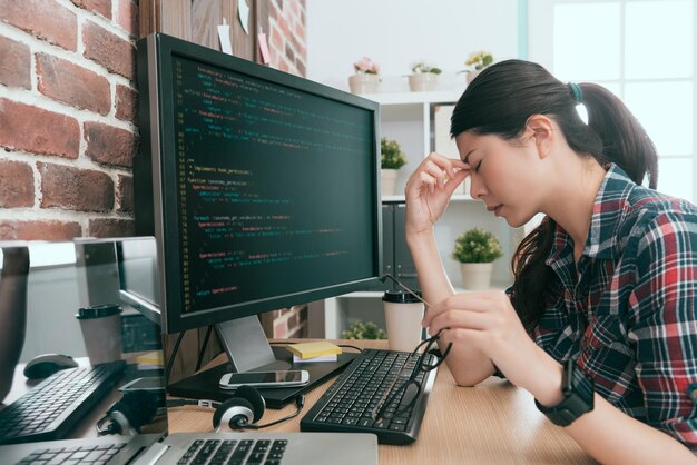 jeune belle femme programmeur utilisant un nouveau système de données de conception informatique se sentant longtemps fatigué et les yeux deviennent mal à l'aise.