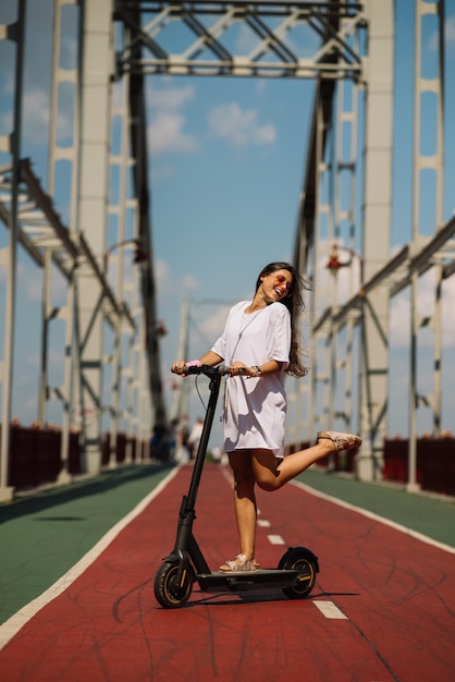 Jeune belle femme et un scooter électrique