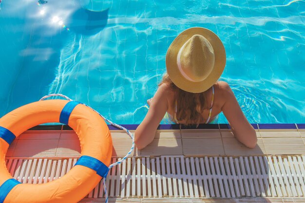 La jeune belle femme se détend et nage dans le plan rapproché bleu de piscine