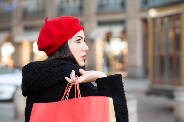 Jeune belle femme souriante faisant ses courses avant Noël