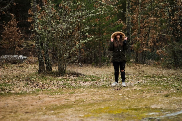 Jeune et belle femme souriante heureuse lors d'une excursion et se promène dans une forêt