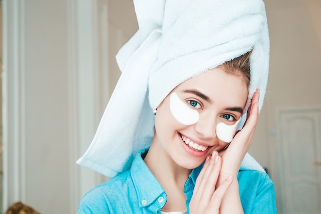 Jeune belle femme souriante avec des taches sous les yeux