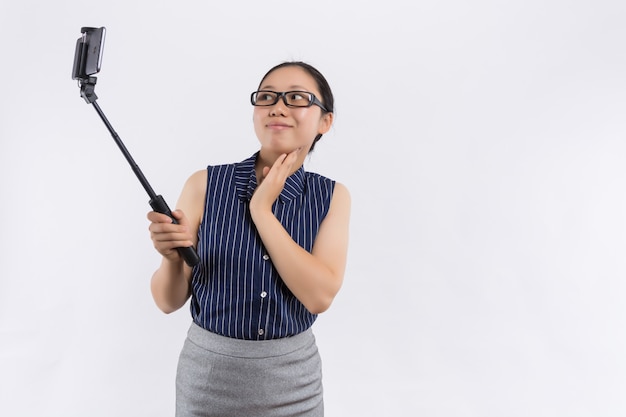 Jeune belle femme sourit à la caméra, prenant selfie