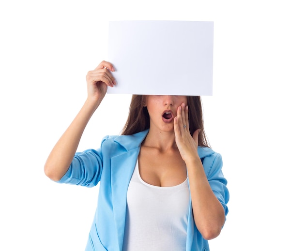 Jeune belle femme en T-shirt bleu veste et jeans tenant une feuille de papier blanche et montrant l'étonnement