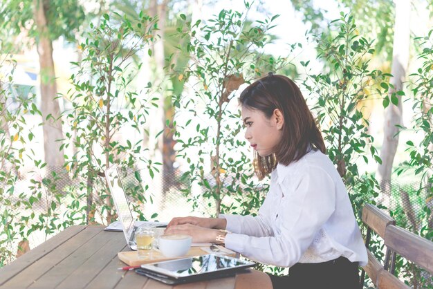 Jeune belle femme thaïlandaise travaille au cafébeau sourirefille d'affaires occupée