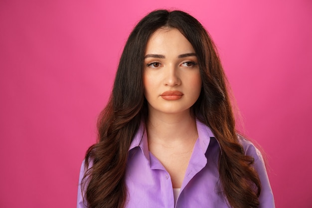 Jeune belle femme triste fond de studio rose sérieux et inquiet