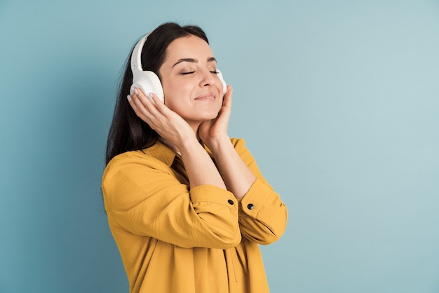 Une jeune et belle fille au casque écoute de la musique et en profite