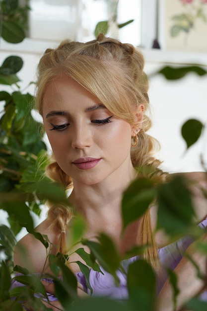 Jeune belle fille blonde en bonne santé avec des tresses et un maquillage clair