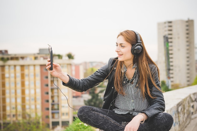 Jeune belle fille brune écoute la musique