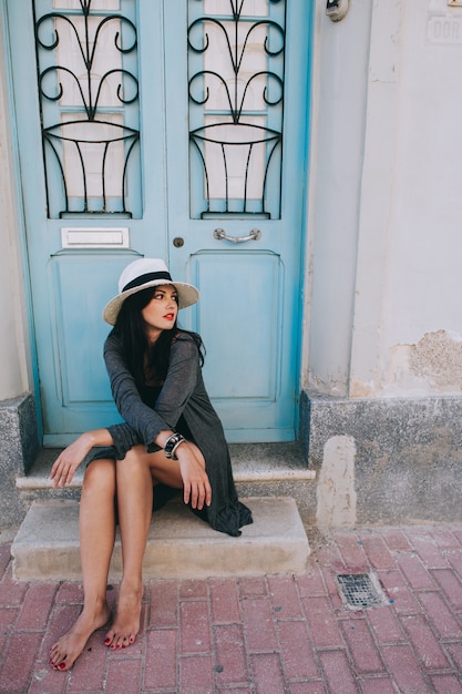 jeune belle fille avec chapeau posant dans le contexte d&#39;une porte vintage