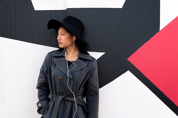 Photo jeune belle fille chinoise chic avec des écouteurs