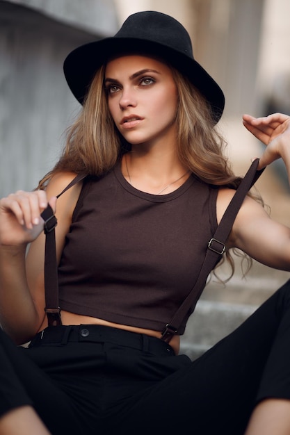 jeune belle fille dans un court haut élégant et un chapeau noir