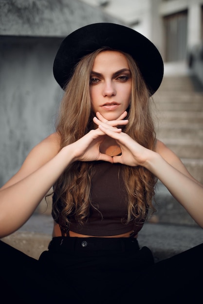 jeune belle fille dans un court haut élégant et un chapeau noir