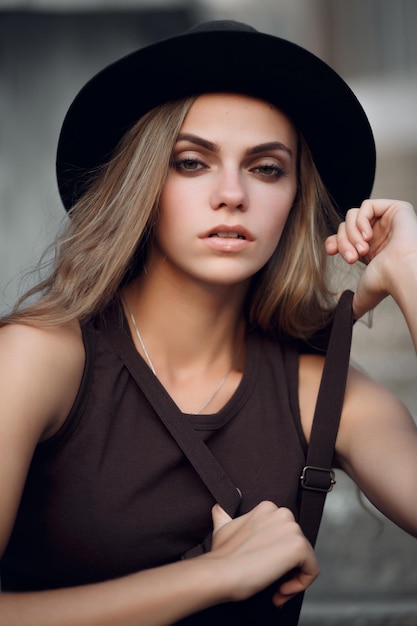 Photo jeune belle fille dans un court haut élégant et un chapeau noir