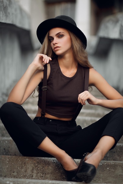 jeune belle fille dans un court haut élégant et un chapeau noir