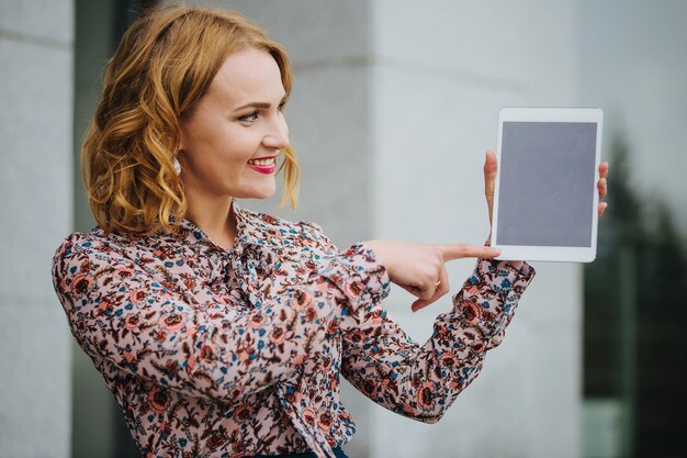 Jeune belle fille dans la rue avec une tablette