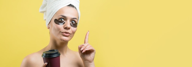 Photo jeune belle fille dans une serviette blanche sur la tête porte des patchs de gel de collagène sous ses yeux