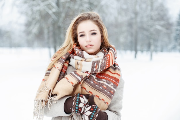 Jeune belle fille avec une écharpe de style vintage et des mitaines en journée d'hiver