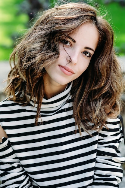 Jeune belle fille avec un joli sourire se bouchent dans le parc