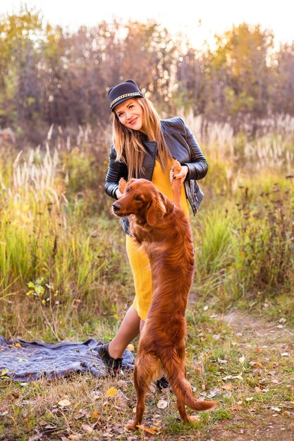 Photo jeune belle fille avec un labrador retriever dans un parc d'automne