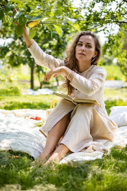 Jeune belle fille lisant un livre papier dans le jardin