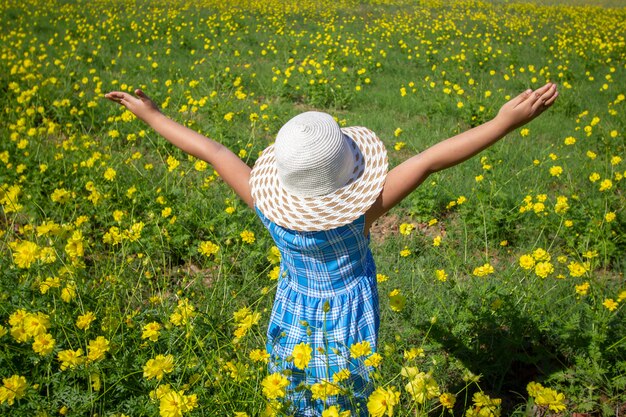 Jeune belle fille marchant et dansant à travers un champ de coquelicot, été en plein air