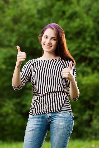 Jeune belle fille montrant deux pouces vers le haut