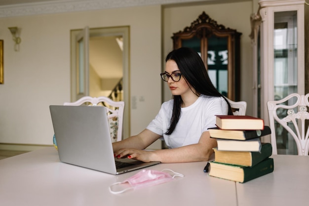 Jeune belle fille avec un ordinateur portable à la maison