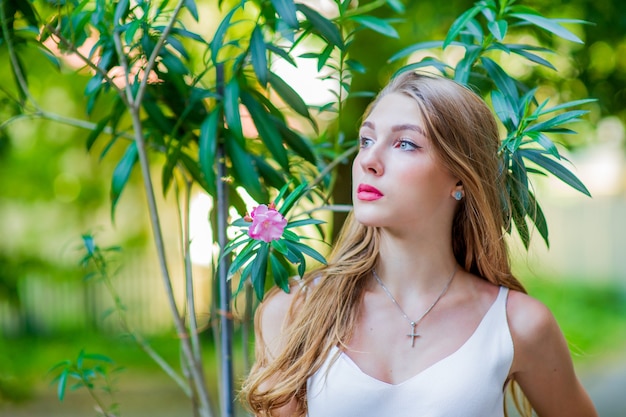 Jeune belle fille posant en plein air, vêtue d'une robe blanche à la mode. Style d'été.