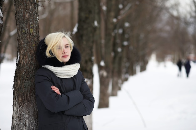 Jeune belle fille sur une promenade dans un parc d'hiver