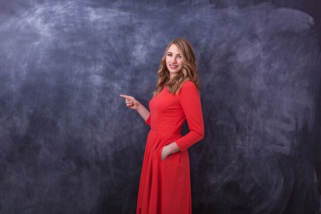 Jeune belle fille en robe rouge montre un geste avec ses mains Humain différent