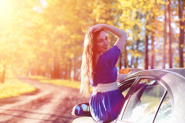 Jeune belle fille en robes sur la nature. Une fille au chapeau se promène dans le parc. Jeune femme sur un pique-nique avec un panier à l'extérieur de la ville.