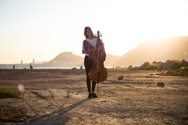 Jeune belle fille avec son violoncelle à l&#39;extérieur