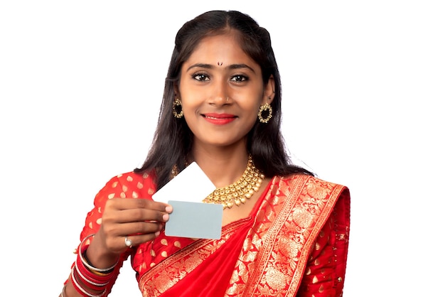 Jeune belle fille souriante posant avec une carte de crédit ou de débit sur fond blanc